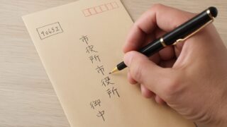 公的書類を送付するために封筒に宛名を丁寧に記入している様子